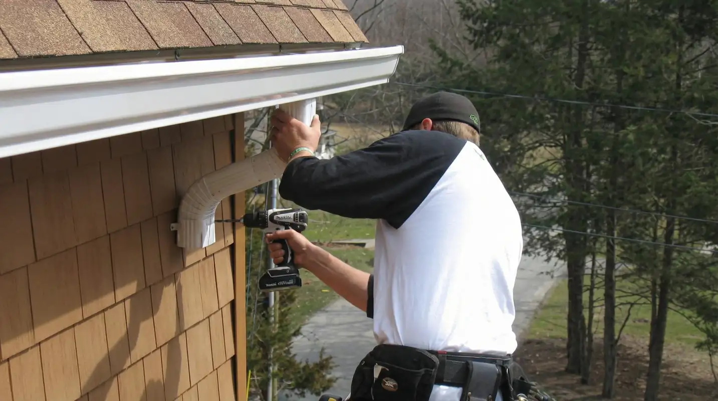 Professional contractor installing tan vinyl siding panels on a residential home exterior in Nashville, TN